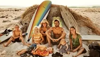 서핑 보드와 함께 해변에 앉아 가족