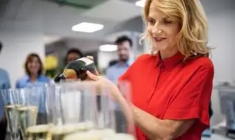 フルートにシャンパンを注ぐ笑顔の実業家