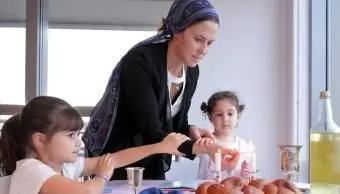 Żydowska rodzina zapala świece szabatowe
