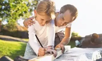 Vater hilft Tochter beim Messen der Planke