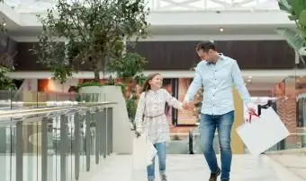 Glücklicher Vater beim Einkaufen mit seiner Tochter im Einkaufszentrum