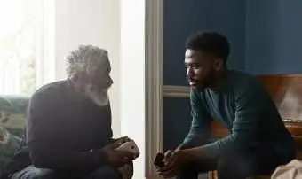 אב ובנו מדברים בישיבה בסלון