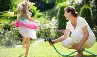 Menina pulando sobre jato d'água