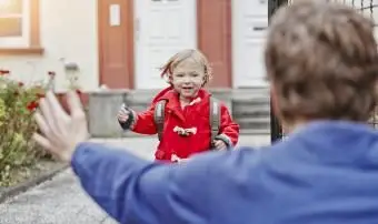 Filha feliz se aproximando do pai na entrada da casa