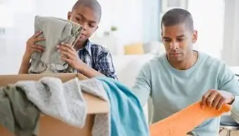 Otec a syn skladajú oblečenie na charitu