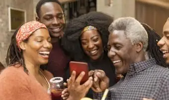 Joyeuse famille multigénérationnelle utilisant un téléphone intelligent