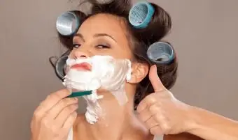 顔を剃るカーラーの女性