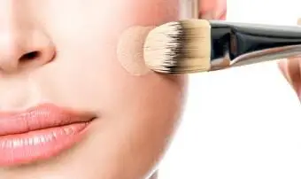 ブラシでファンデーションを塗る女性