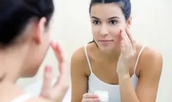 顔にクリームを塗る女性