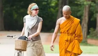 Turista caminando con monje local.