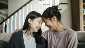 Mère et fille adolescente parlant à la maison