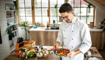 皿を持っている若いシェフ