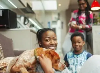 דיוקן משפחה מחייכת עם כלב בבית