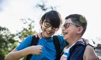 בני דודים בגיל בית הספר צוחקים בחוץ