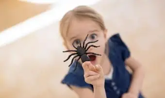 Ragazza con ragno finto