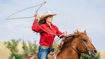 Kowbojka rzucająca lasso na koniu