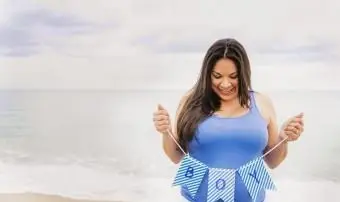 해변에서 소년 배너를 들고 임신 한 여자