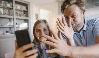 電話で話している遊び心のある父と娘