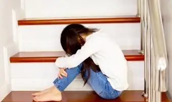 Bambino che piange sulle scale