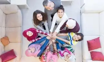 משפחה מודרנית מוסלמית עם ידיים ביחד