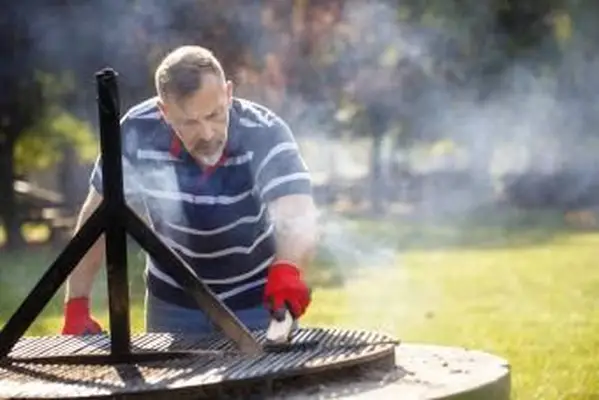 バーベキューグリルを掃除する男