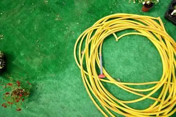 Manguera de riego sobre un césped artificial verde