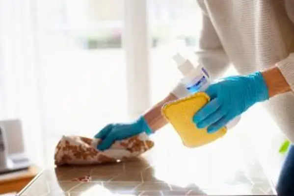 消毒スプレーでテーブルを掃除する女性