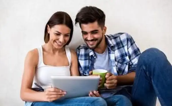 Couple jouant à un jeu en ligne sur tablette