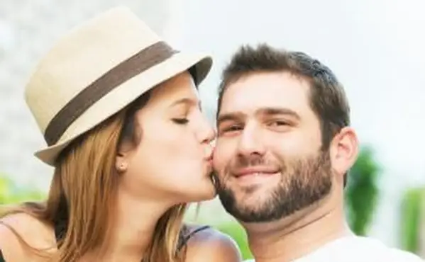 אישה נותנת לחבר שלה נשיקה על הלחי