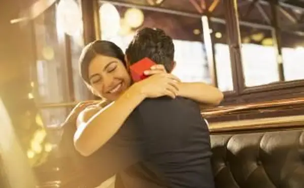 贈り物を受け取った後、パートナーを抱き締める女性