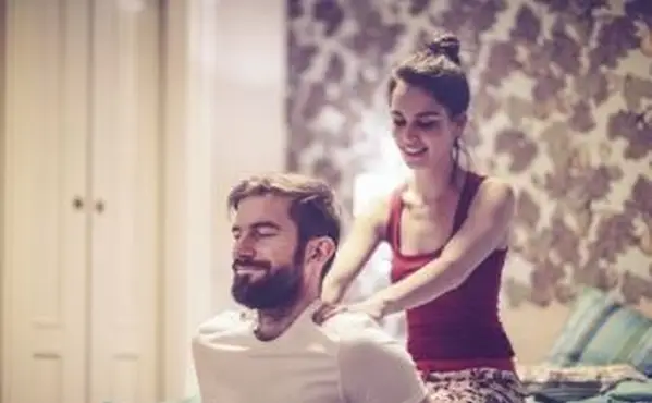 Frau reibt ihrem Freund den Rücken