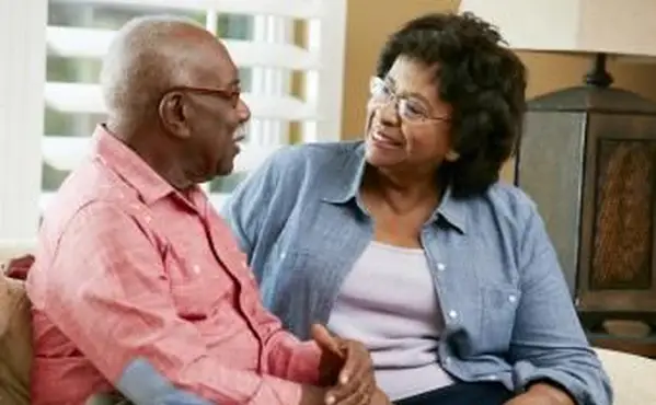 זוג בכיר יושב על ספה בבית