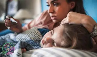 Mamma che misura la temperatura sul bambino malato