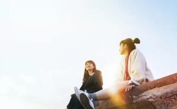 2 Freunde sitzen an einer Wand