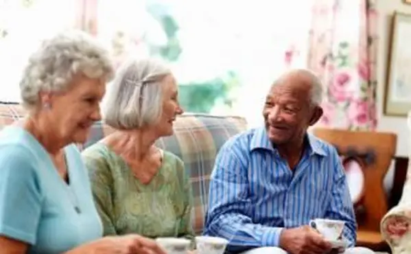 Trois personnes âgées prenant un café
