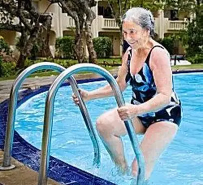 mulher nadando na piscina no apartamento sênior