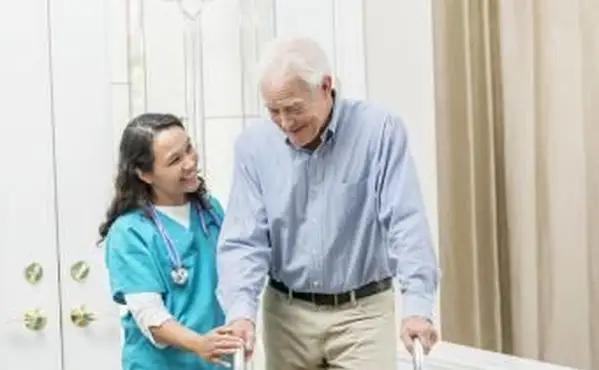 Trabalhador de saúde domiciliar ajudando idoso com andador