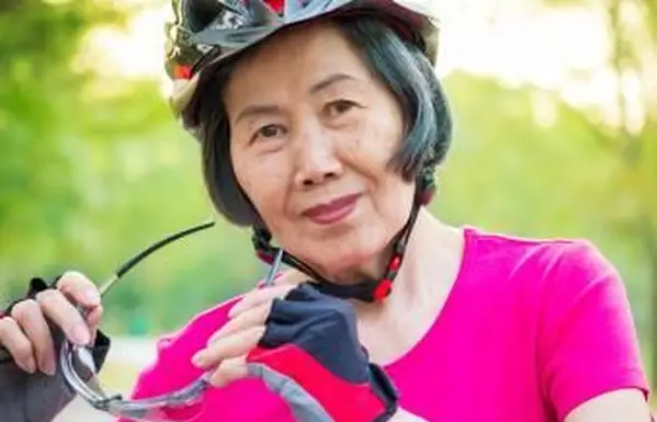 אישה בכירה, לובשת כפפות אופניים