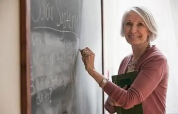 Professor escrevendo no quadro-negro