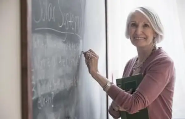 黒板に書く年配の女性