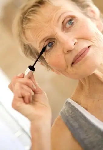 まつ毛にマスカラプライマーを塗る女性