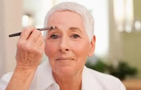 化粧をしている年配の女性