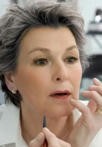 化粧をしている年配の女性