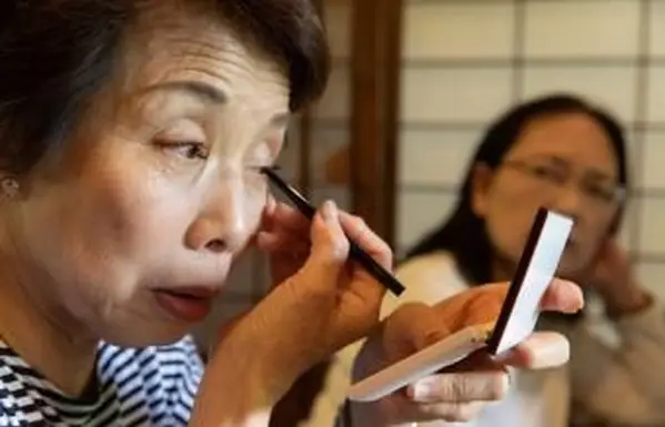 アイメイクをしている年配の女性