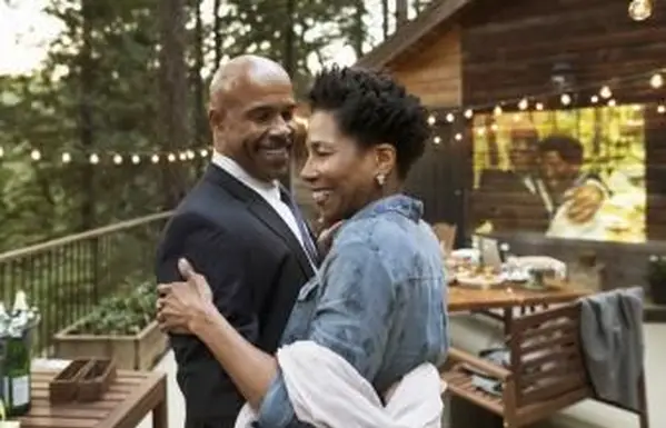Coppia che balla alla festa di anniversario sul balcone della cabina nei boschi
