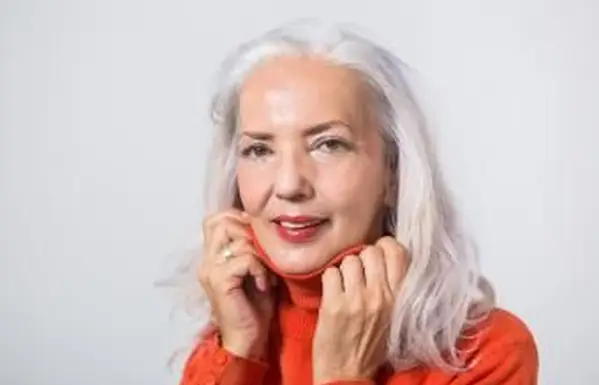 桃色のフラッシュメイクで笑顔の年配の女性