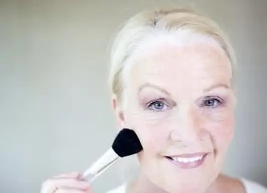 メイクをする年配の女性