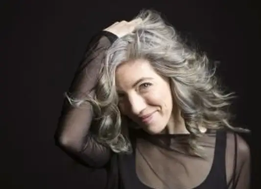 Femme confiante avec la main dans les cheveux gris