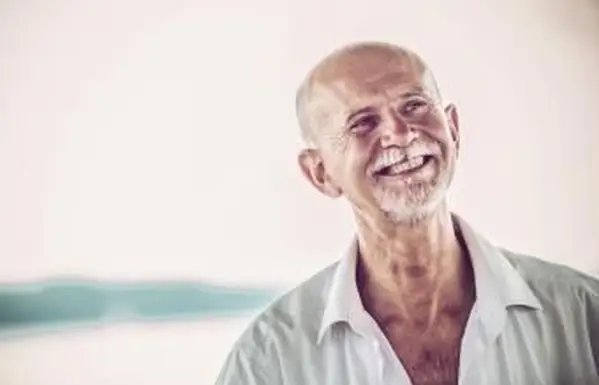 Homme aîné gai avec la barbe blanche dehors