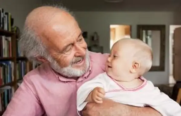 Starý otec a dieťa sa usmievajú doma